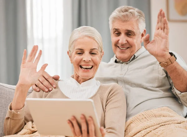 Home, video call and old couple with a tablet, wave and hello with connection, social media or retirement. Technology, elderly man or senior woman on a couch, network or online chatting with greeting.