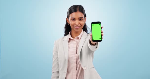 ハッピーな女性 ビジネス 広告スペースのための携帯電話の緑の画面を指摘し スタジオでオファーとモックアップニュースレターにサインアップします インド人労働者の肖像画は青い背景でモバイルアナウンスを示しています — ストック動画
