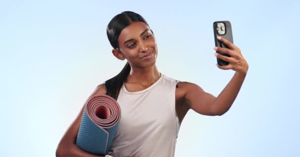 印度女人 在健身房里自拍 带着锻炼垫的瑜伽 社交媒体的记忆 蓝色背景的快乐 形象画中的健美 柔毛与训练及演播室的影响因素 — 图库视频影像