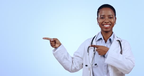 広告やマーケティングのためのモックアップとスタジオで女性医師の指摘 幸せで顔 青い背景でショーハンドジェスチャーでアフリカの女性医療従事者の笑顔 モックアップ — ストック動画