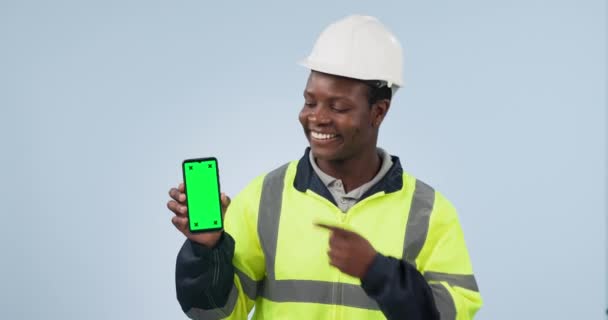 ハッピーブラックマン エンジニア 電話グリーンスクリーン スタジオのバックグラウンドでマーケティング モバイルスマートフォンアプリの表示やモックアップを指すアフリカの男性 建築家 請負業者の肖像画 — ストック動画
