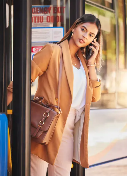 Business, woman or phone call at bus stop for travel or location with public transport for commute in urban city. Professional, corporate or person with smartphone and chat, talking or transportation.