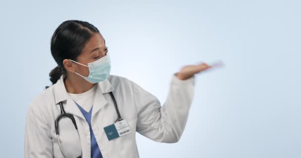 面罩和医生指向手掌产品的摆放 健康品牌选择或心脏科服务提供 工作室外科医生肖像 健康模拟空间和蓝色背景的医疗大使 — 图库视频影像