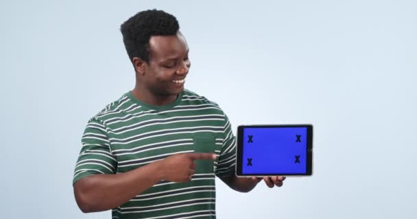 タブレットスクリーン 幸せな黒人男性 ブランド オンラインロゴデザイン 商業モックアップスペース ニュースや取引を指す ポートレート トラッキングマーカー スタジオの人は青い背景でグラフィックオファーを示します — ストック動画