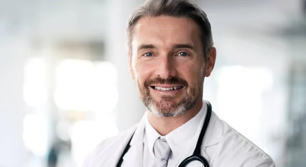 Mature doctor, portrait and happy man in hospital for healthcare, wellness and career in clinic. Face, medical professional smile and confident expert surgeon, therapist worker and employee in Canada.