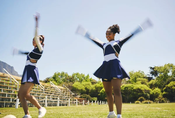 Dance, cheerleading and women on a field for training, teamwork and a performance for a game. Cheerleader, happy and a team with a routine, sports or motivation for an event on school grass together.