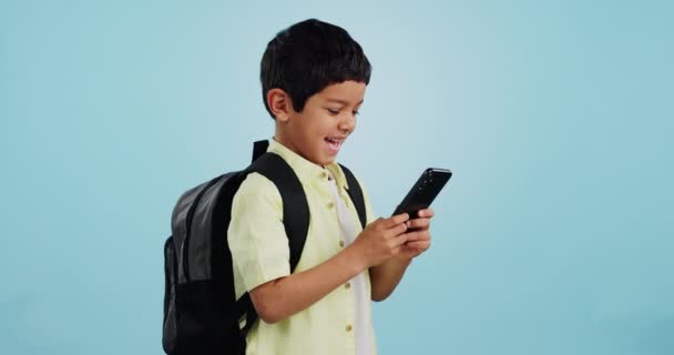 スタジオのソーシャルメディアで学校 子供がチャット モバイルゲームをプレイしたり アプリをダウンロードしたりします 青い背景 学生や幸せな少年 オンライン教育や技術検索のための通知を読む — ストック動画