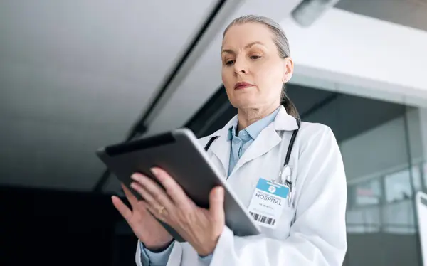 Woman, doctor and tablet in research, communication or Telehealth for results or networking at hospital. Female person, healthcare or medical surgeon working on technology for online search at clinic.