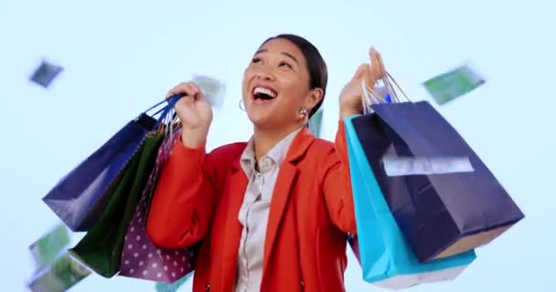 ショッピングバッグ お祝いとスタジオでお金の雨のために幸せ ブルーバックグラウンドで販売と取引 日本人 勝者少女 キャッシュシャワー ギフト ダンス プレゼントの成功 — ストック動画