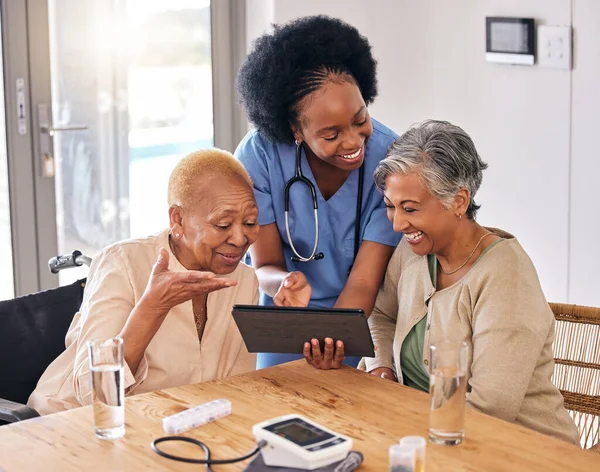 Tablet, smile and an assisted living nurse with old women in the kitchen of a retirement home for consulting. Technology, medical and an african caregiver showing information to patient friends.