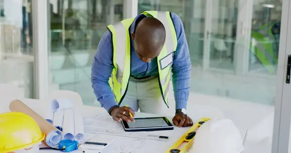 Black man, tablet and review floor plan, construction or architect working on maintenance job in office. Assessment, digital blueprint for architecture project and productivity with design software.