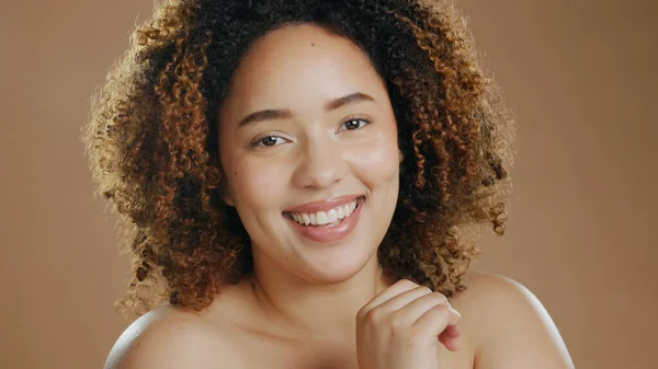 Face of happy woman, natural beauty dermatology and cosmetic wellness in studio with smile. Skin glow, portrait or confident biracial female model with skincare results or pride on brown background.