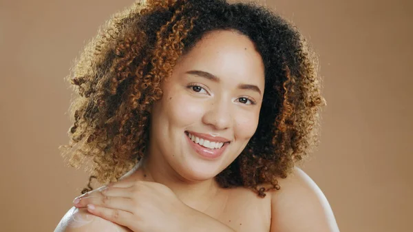 Portrait of happy woman, natural beauty or healthy skin for wellness in studio with smile or glow. Dermatology, cosmetics or confident biracial girl model with skincare results on brown background.