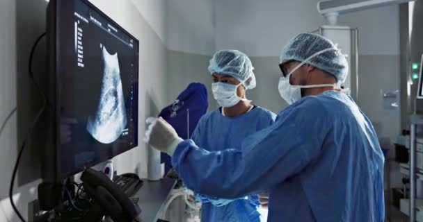 扫描和一组医生在医院进行手术或手术切除肿瘤 医疗保健 医疗团队合作和一名医生在屏幕上与一名医学专业人员对视 — 图库视频影像