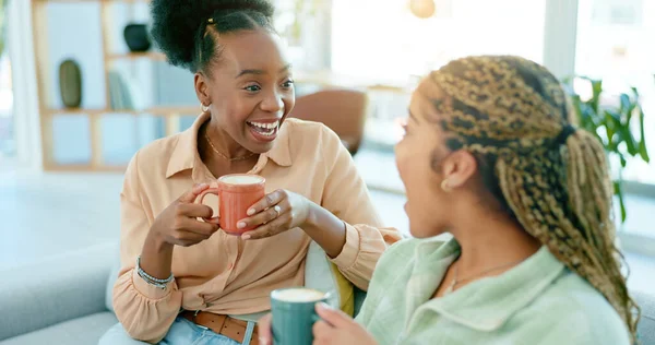 Happy, talking and women with coffee on the sofa for gossip, secret or conversation in a house. Excited, relax and a black woman with a girl or friends with communication, tea and story on the couch.