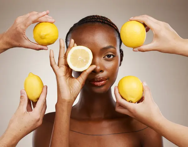 Hands, lemon and natural beauty, black woman in portrait for wellness and sustainable skincare on brown background. Health, nutrition and fruit, dermatology and vegan product with vitamin c in studio.