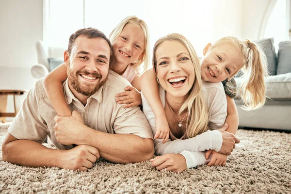 Happy, smile and portrait of family in the living room bonding, hugging and relaxing together. Happiness, love and girl children laying with parents from Australia on floor in lounge at modern home