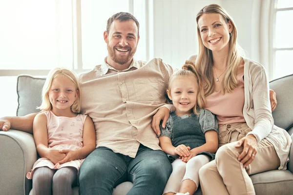 Happy family, portrait and relax on living room sofa for bonding, weekend or holiday together at home. Mother, father and children smile, hug and sitting on couch for summer break or rest at house.