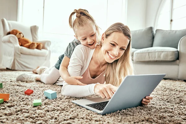 Mother, girl and laptop for home games, e learning and funny video streaming or education on carpet in living room. Excited mom, family and child play on floor on computer, kids website or internet.
