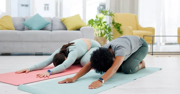 Friends, yoga and women in child pose stretching for wellness, healthy body and training on floor. Balance, performance and people on gym mat for pilates, holistic exercise and workout in living room.