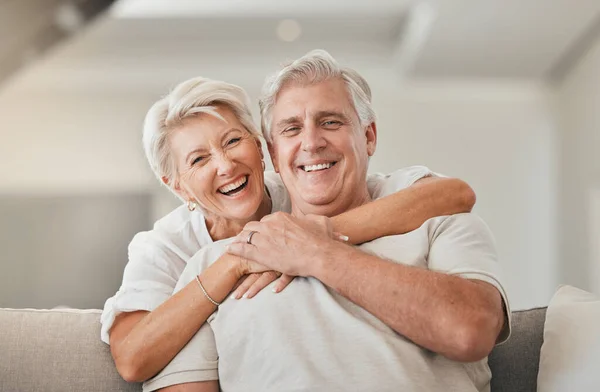Happy senior couple, portrait and hug on living room sofa for embrace, relationship or love at home. Mature woman hugging man with smile in happiness for care, support or trust together in house.