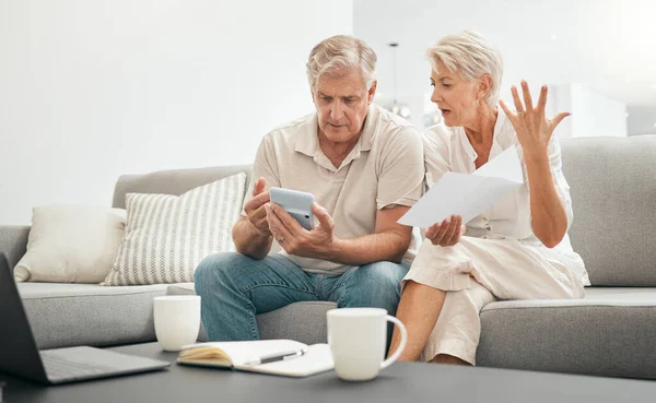 Frustrated senior couple, documents and financial crisis on living room sofa in debt, expenses or bills at home. Mature man and woman checking finance, paperwork or budget with calculator for invoice.