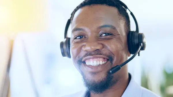 Portrait, call center and smile of black man in telemarketing, support and help desk in office in Nigeria. Customer service, sales agent and happy face of African business professional in headphones.