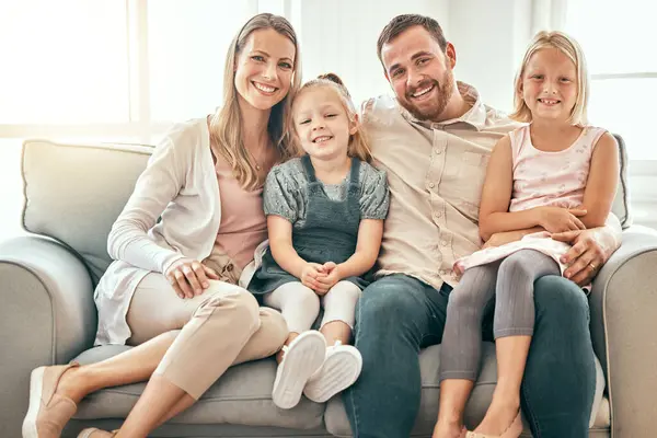 Happy, love and portrait of family on a sofa in the living room bonding and relaxing together at home. Happiness, Smile and girl children sitting with parents from Australia on floor in the lounge