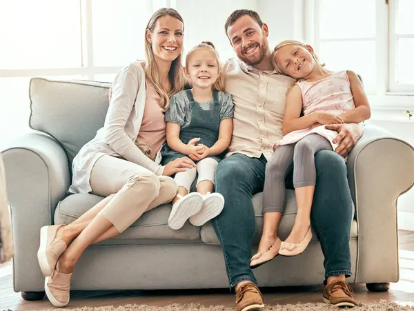 Smile, love and portrait of family on a sofa in the living room bonding and relaxing together at home. Happiness, care and girl children sitting with parents from Australia on couch in the lounge
