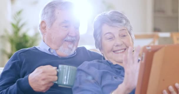 ソファーの上のタブレット コーヒー シニアカップルは ソーシャルメディア上でリラックスして結合し ネットワーキングを一緒にします スマイル デジタルテクノロジー 高齢者のリビングルームでインターネット上の退職スクロール — ストック動画