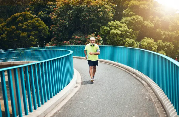 Old man on bridge, speed walking for fitness and cardio, training or running with wellness and vitality. Runner in street, performance and challenge with exercise, health and workout in retirement.