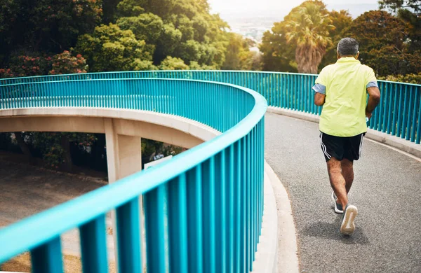 マラソン ウェルネス 活力のためのスピードとトレーニングでバックビュー フィットネスと心臓のために走る橋の上の老人 ストリートでランナー パフォーマンスと運動 健康とトレーニング — ストック写真