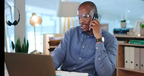 Businessman, working and phone call in office, discussion and conversation on proposal, report and project. Black person, talking and planning on laptop, corporate and schedule for agenda on tech.