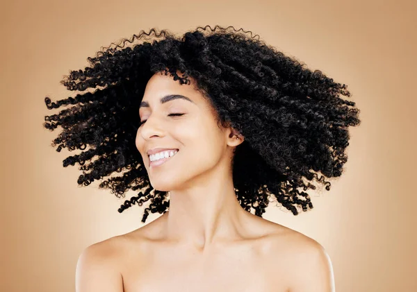 Woman, curly or hair shake in afro fun on studio background for healthy hairstyle growth, texture or frizz treatment success. African beauty model, energy or change by shampoo transformation results.