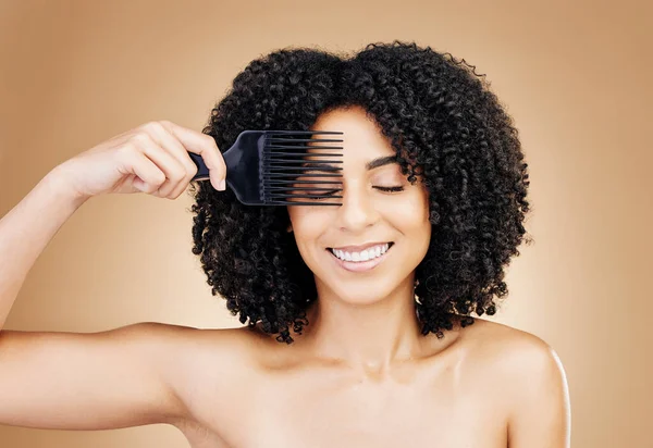 Hair, comb and happy woman with afro as style isolated in a studio brown background for wellness and skincare. Texture, natural and young person with cosmetic aesthetic in Brazil hairdresser.