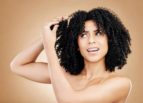 Hair, frustrated and woman with afro knots, frizz and isolated in a studio brown background with wellness and skincare. Comb, damage and confused person with cosmetic aesthetic in Brazil hairdresser.