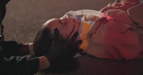 緊急時の事故 首のブレース 夜間および救急隊員 被害者の顔 クローズアップ 災害からの救助 最初の援助および飲酒運転のための酸素マスク — ストック動画