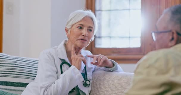 コンサルタント 家庭で医療 アドバイスの患者を持つ女性 ソファーのヘルスケア クリニック シニアの人々は リビングルームで診断 健康のために話します — ストック動画