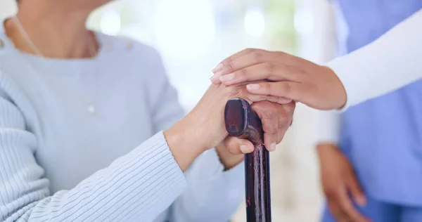 Nurse, holding hands and support woman with cane, empathy and trust in retirement home. Comfort, closeup of caregiver and senior person with a disability, walking stick and help, kindness and health.