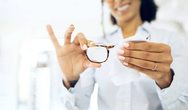 Hands, woman is cleaning glasses with fabric and hygiene, vision and eye care with health and wellness. Eyewear, maintenance and wipe away dust with microfiber cloth, closeup and frame with lens.