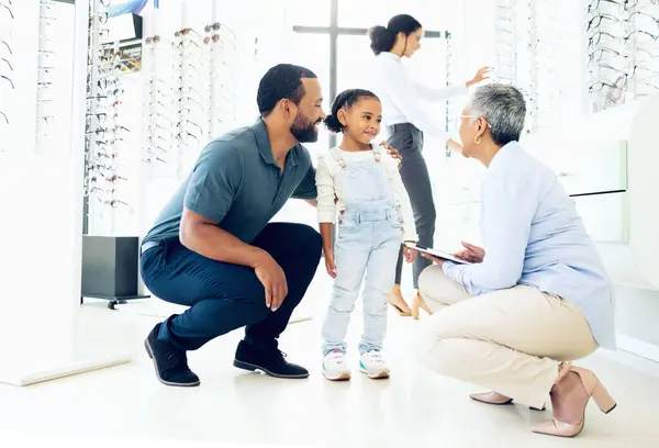 Optometrist, father and child for eye care, optometry or vision assessment or test in clinic or store. Man, senior woman or girl kid at optician for eyesight appointment for focus or glasses with joy.