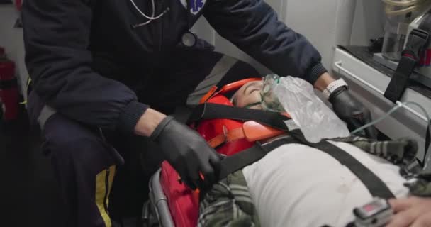 救急車に酸素マスクを装着した患者 男性が首のブレースで緊急 または医療を受けています ファーストレス 911および医療 サポートまたは犠牲者のチェックのための麻酔を有する人 — ストック動画