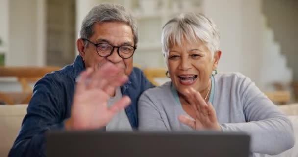 シニア カップル ビデオ通話 波とラップトップ リビングルームのソファーで幸せと挨拶 高齢者 コミュニケーション ネットワーキングや会話のためのコンピュータ上で笑顔の男女 — ストック動画
