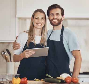 Evde birlikte sağlıklı bir vegan diyeti için tablet ya da yiyecekle yemek pişirme, portre yapma ya da mutlu bir çift. Gülümse, sebze ya da kadının aşkla bağ kurması ya da erkeğin internette yemek tarifini öğrenmesi..