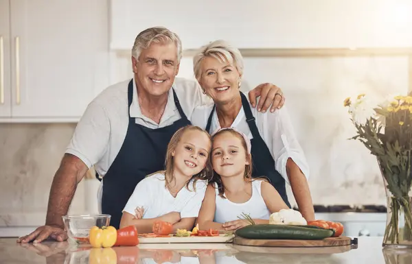 Happy family, portrait and grandparents with grandkids cooking in a kitchen with vegetables. Food, learning and face of kids with old people with love, fun or preparing healthy, nutrition or meal.
