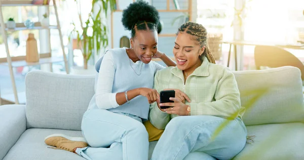 Woman, friends and phone on sofa in living room after vacation in home with memories on social media. African, people and happy by together, relax or bond after trip for online, web or wellness.