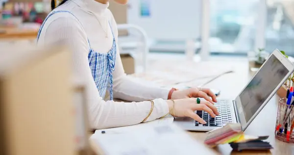 Ecommerce, hands of woman at laptop with typing and writing sales report for work at fashion startup. Online shopping, boxes and small business owner with happiness, computer and website shop at desk.