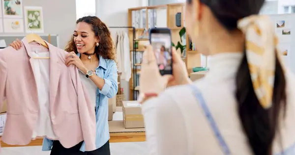 Fashion influencer, cellphone and women live streaming clothes presentation, style review or mobile app broadcast. Phone, content creator team and small business owner teamwork on retail commercial.