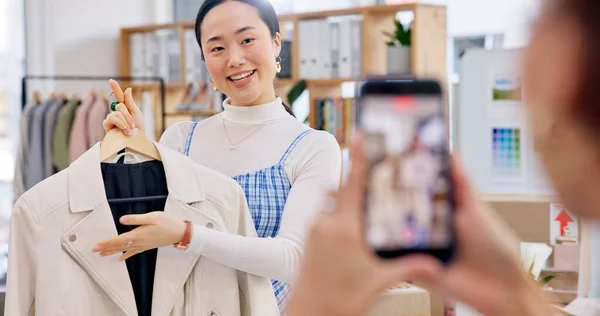 Fashion influencer, phone and Asian woman live streaming clothes, leather jacket design or shooting vlog commercial. Cellphone recording, social media app and Japanese person explain retail product.