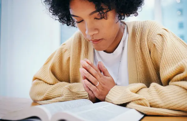 Bible, praying and woman in home for religion, Christian worship or reading to study. Person, holy book and meditation at desk for God, Jesus Christ and faith in spiritual gospel, praise and hope.